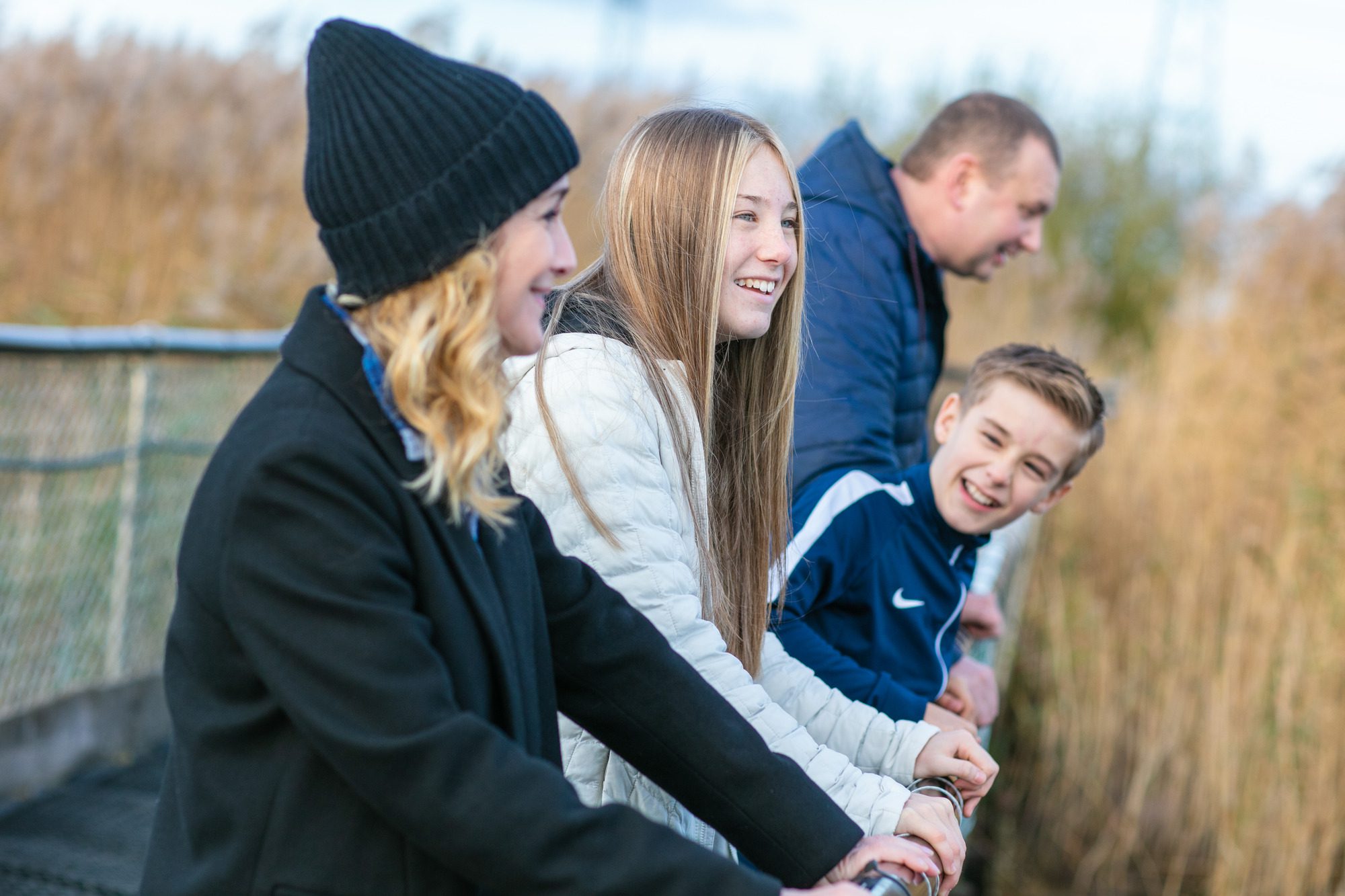 A family standing on a bridge and laughing