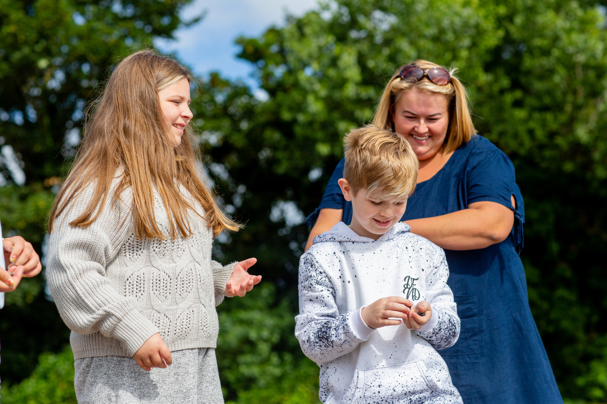 A family smiling and playing outdoors
