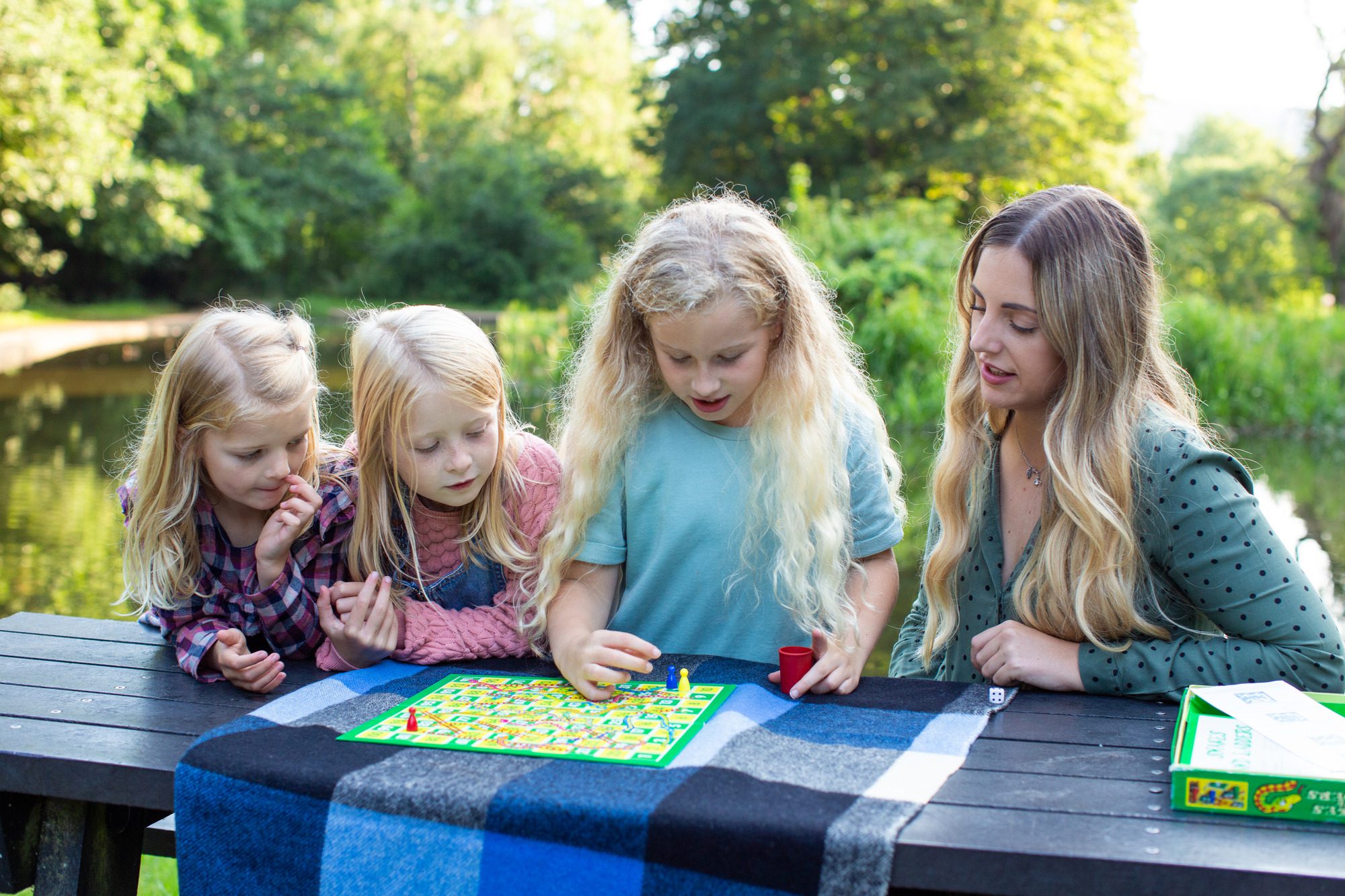 A woman and three girls playing game outside