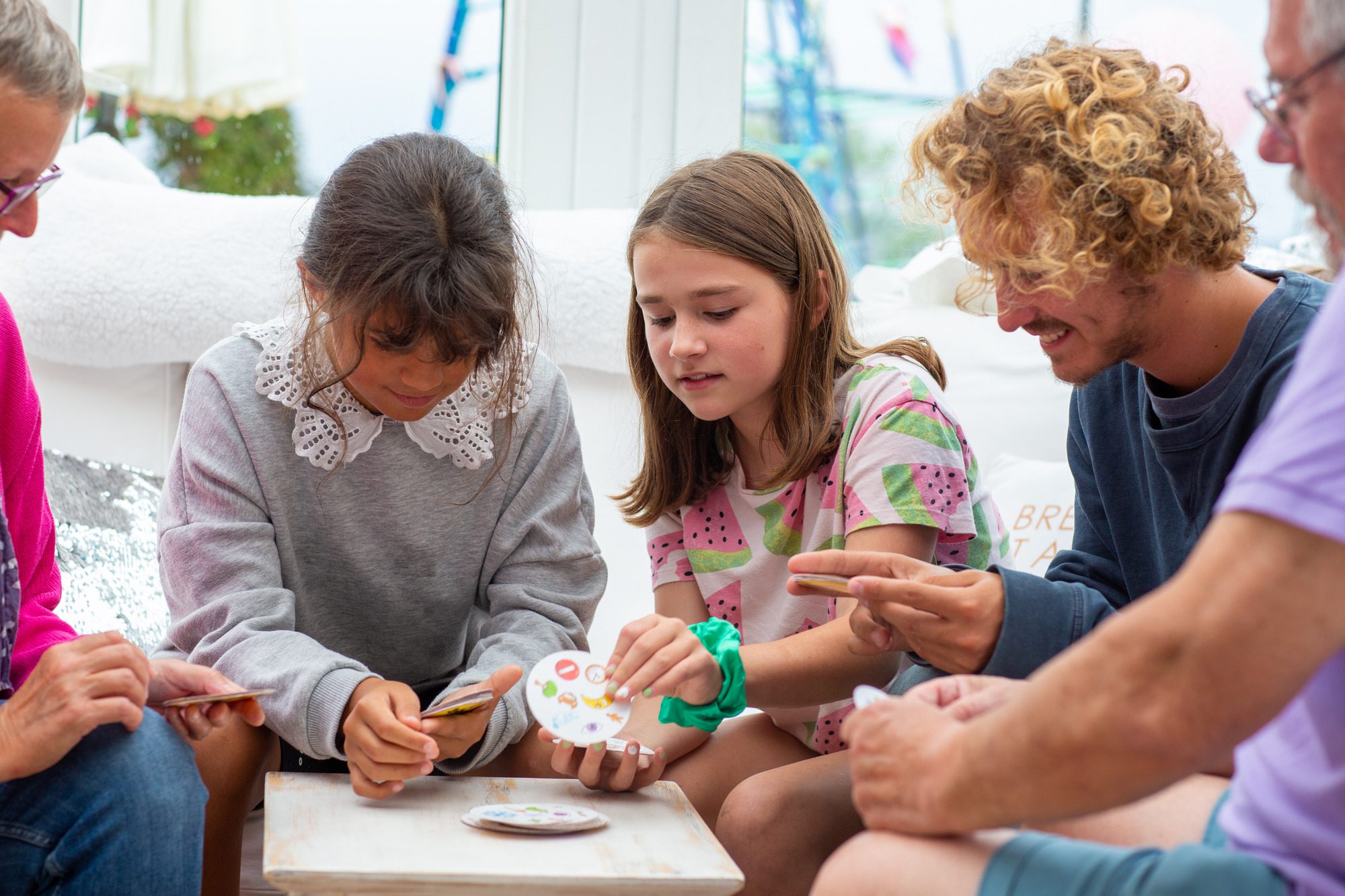Family around the small table playing game